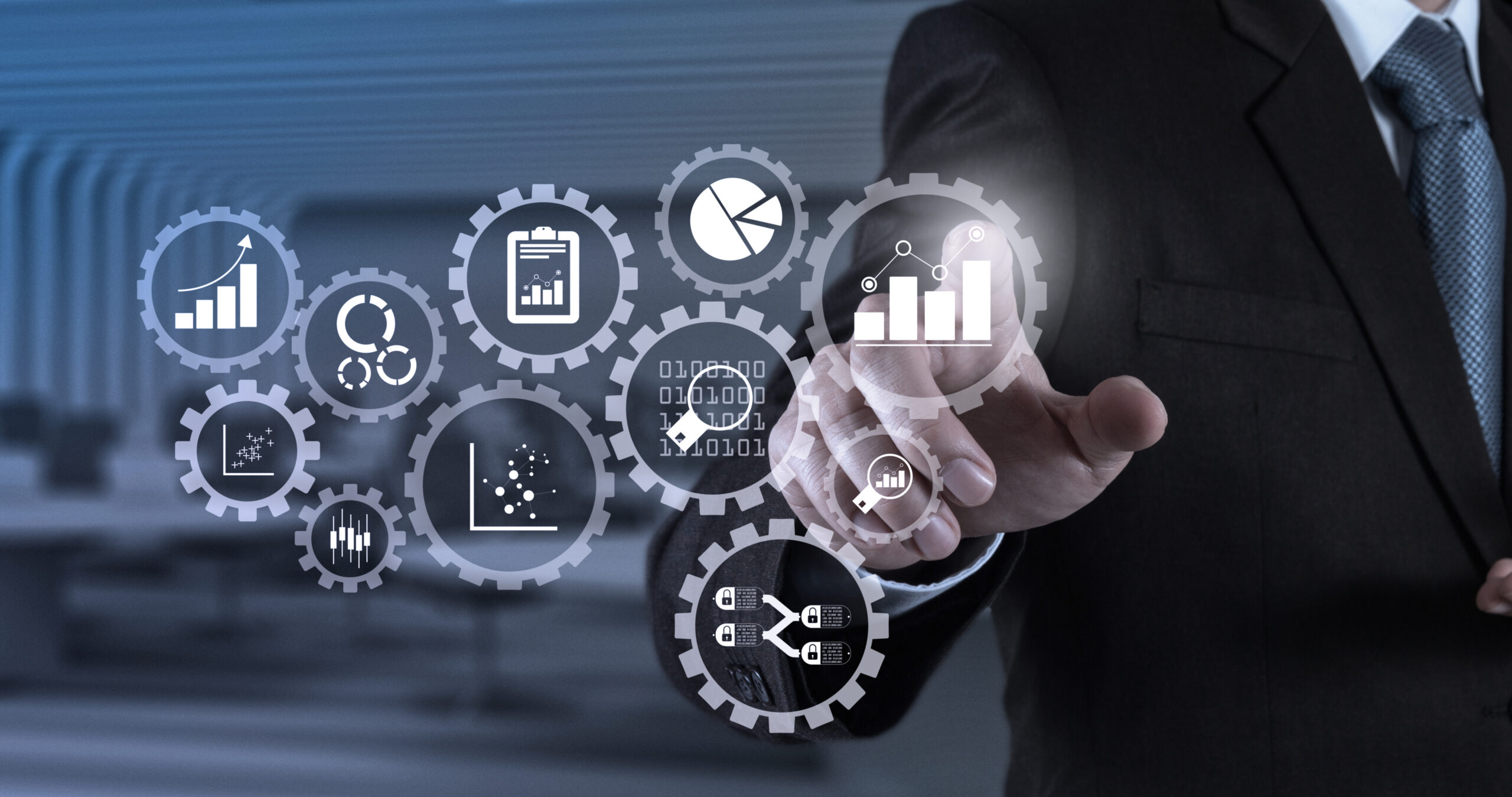 Business data analytics management with connected gear cogs with KPI financial charts and graph.Businessman hand pressing an imaginary button on virtual screen